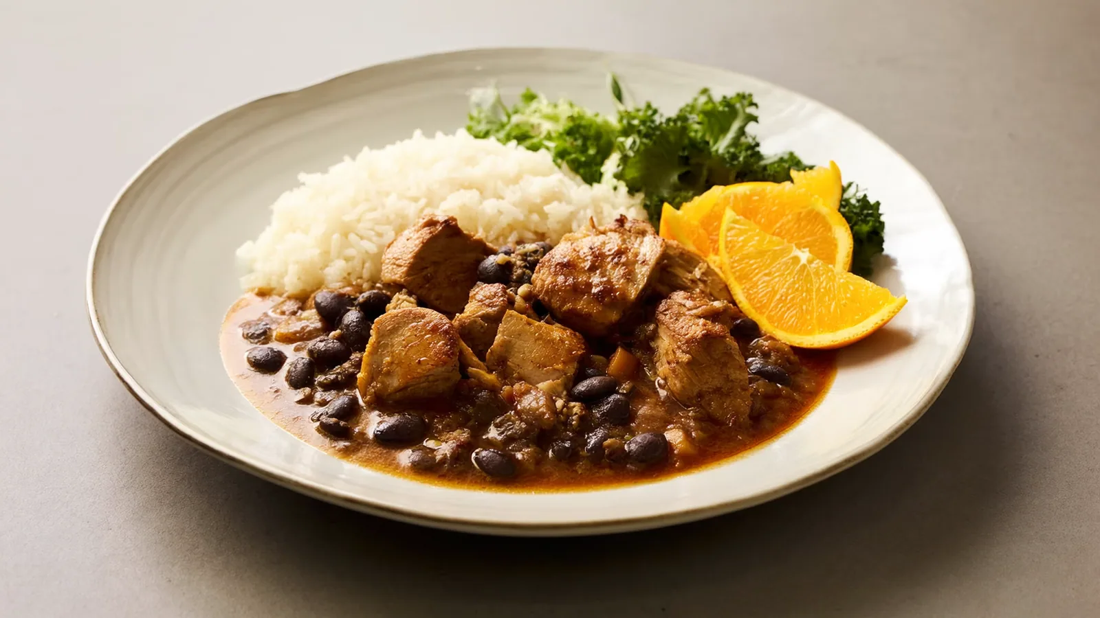 Brasilianische Feijoada mit schwarzen Bohnen, Fleisch und Orangenspalten