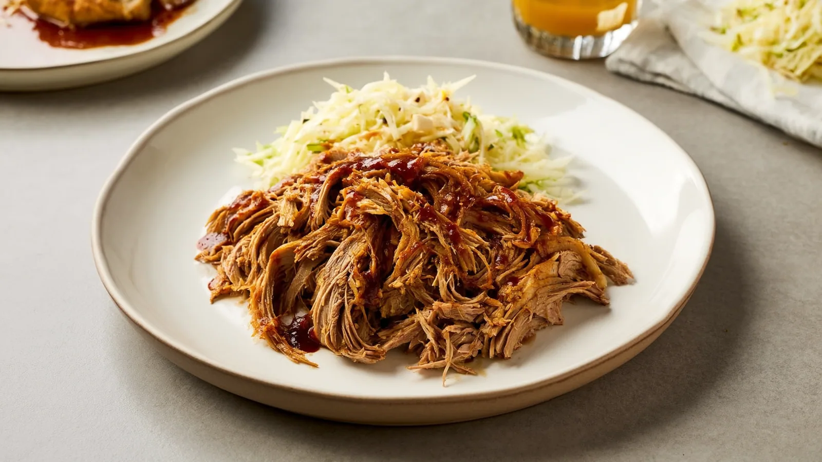 Gezupftes Pulled Pork mit dunkler Barbecuesauce und Krautsalat